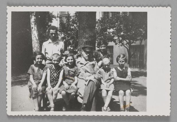 Fotografia przedstawiająca Janusza Korczaka (Henryka Goldszmita) w otoczeniu dzieci przed Domem Sierot