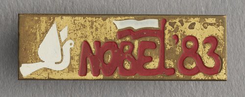 Przypinka z napisem 'Nobel '83' z wizerunkiem gołębia