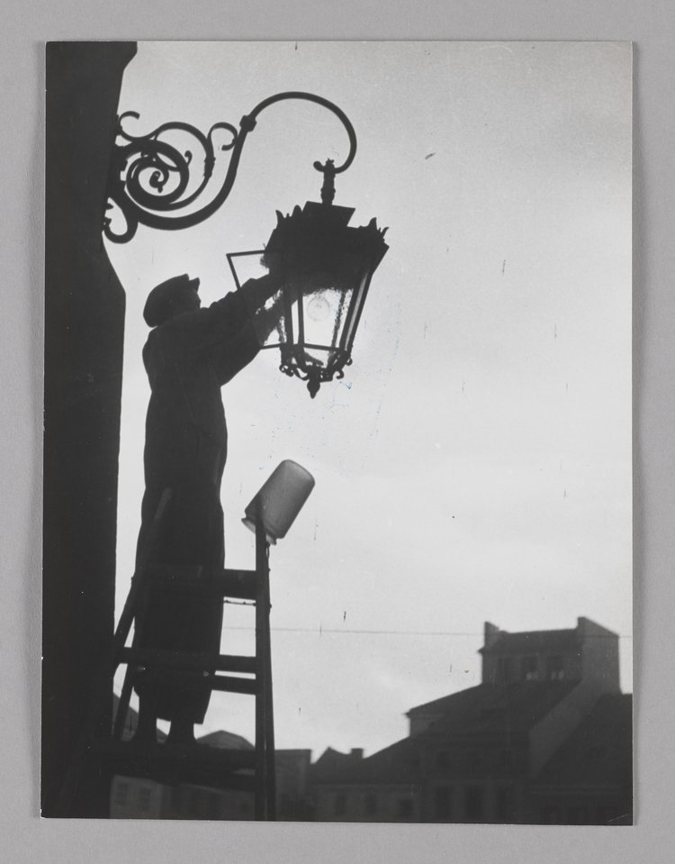 Changing the light bulb of a street lamp in Old Town Market Square