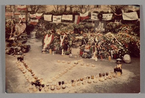 Grób bł. ks. Jerzego Popiełuszki, który został usłany wieńcami i wiązankami, a przed nim ustawiono znicze w kształt litery "V" oraz krzyża