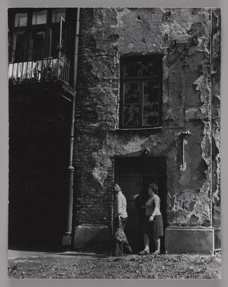 Dwie kobiety wychodzące z klatki schodowej kamienicy przy ulicy Siedleckiej 27