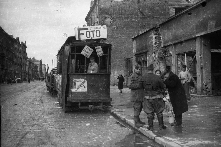 Prowizoryczny punkt usługowy ulicznego fotografa przy zniszczonym wagonie tramwajowym na ulicy Marszałkowskiej