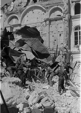 Grupa powstańców podczas odgruzowywania zbombardowanej części gmachu Towarzystwa Kredytowego Ziemskiego