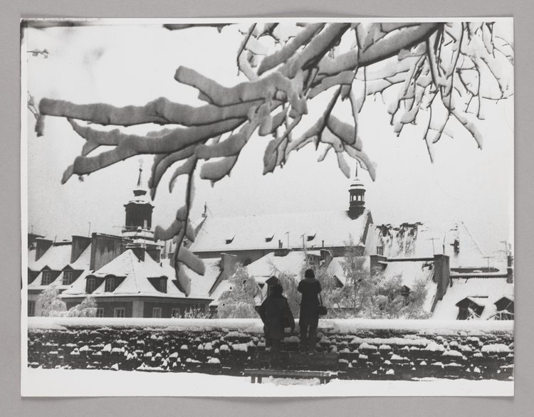 Widok na dachy kamienic przy ulicy Mostowej oraz dach kościoła pw. św. Jacka zimą