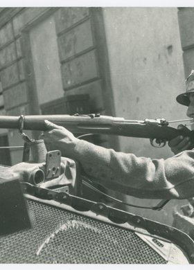 Powstaniec z karabinem na barykadzie