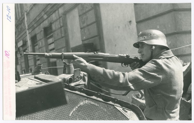 Powstaniec z karabinem na barykadzie