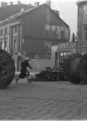 Kobieta przebiegająca ulicą Nowy Świat