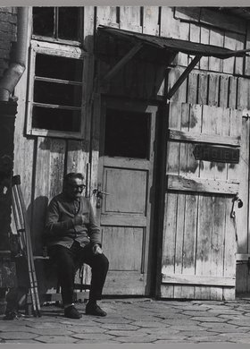 Mężczyzna siedzący przed maglem na podwórzu przy ulicy Konopackiej 6