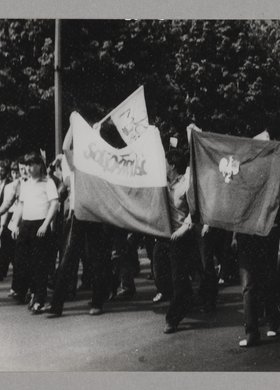 Marsz ulicami miasta protestującego tlumu - niosą flagi biało - czerwone oraz transparenty z napisami "SOLIDARNOŚĆ"