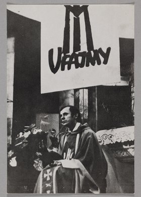 Reprodukcja zdjęcia bł. ks. Jerzego Popiełuszki podczas jednej z tzw. "Mszy za Ojczyznę" - ukazje kapłana siedzącego przy ołtarzu