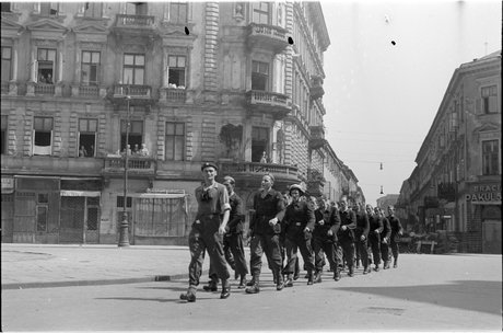Powstańczy oddział maszerujący ulicą Chmielną
