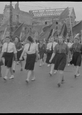 Grupa dziewcząt maszerująca w pochodzie ulicą Bonifraterska