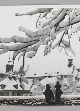 Widok na dachy kamienic przy ulicy Mostowej oraz dach kościoła pw. św. Jacka zimą