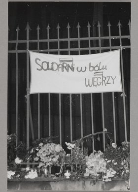 Pogrzeb bł. ks. Jerzego Popiełuszki - fragment ogrodzenia kościoła p.w. św. Stanisława Kostki na warszawskim Żoliborzu z zawieszonym transparentem oraz wiązankami kwiatów