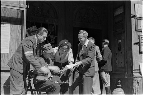 Powstańcy czytający niemiecka ulotkę