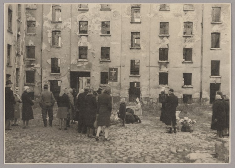 Mieszkańcy podczas święta zmarłych w miejscu egzekucji na podwórzu kamienicy przy ulicy Wolskiej 102
