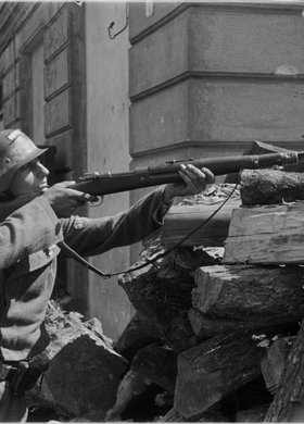 Powstaniec z karabinem na barykadzie