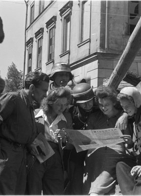 Powstańcy czytający "Biuletyn Informacyjny" na barykadzie