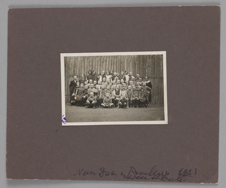 Fotografia przedstawiająca Marię Falską i Janusza Korczaka (Henryka Goldszmita) z dziećmi i wychowawcami w Naszym Domu