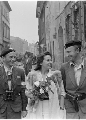 Powstańcy i kobieta z bukietem róż