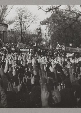 Pogrzeb bł. ks. Jerzego Popiełuszki - tłum ludzi trzymających transparenty oraz unoszących prawe ręce w górę i tworzących dwoma palcami literę "V"