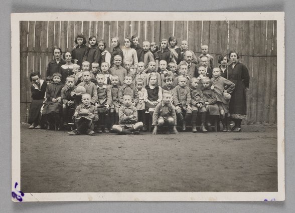 Fotografia przedstawiająca Marię Falską i Janusza Korczaka (Henryka Goldszmita) z dziećmi i wychowawcami w Naszym Domu