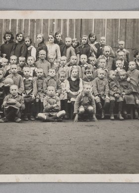 Fotografia przedstawiająca Marię Falską i Janusza Korczaka (Henryka Goldszmita) z dziećmi i wychowawcami w Naszym Domu