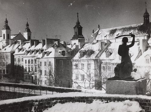 Pomnik Syreny na murach obronnych zimą; w tle kamienice przy ulicy Mostowej