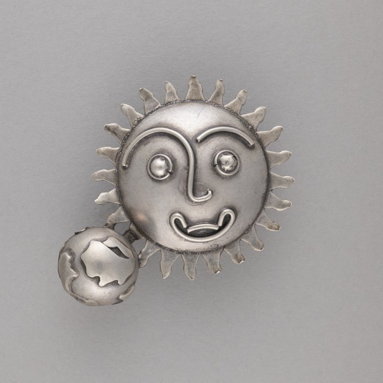 Broszka ze słońcem - maską solarną i ziemią