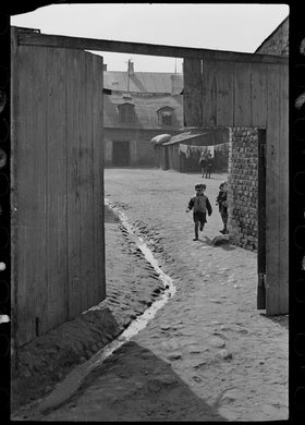 Chłopiec na potwórzu między "drewniakami" przy ulicy Ostroroga 33 lub 23 na Woli