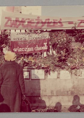 Ogrodzenie kościoła p.w. św. Stanisława Kostki w Warszawie z zawieszonymi kwiatami i transparentami