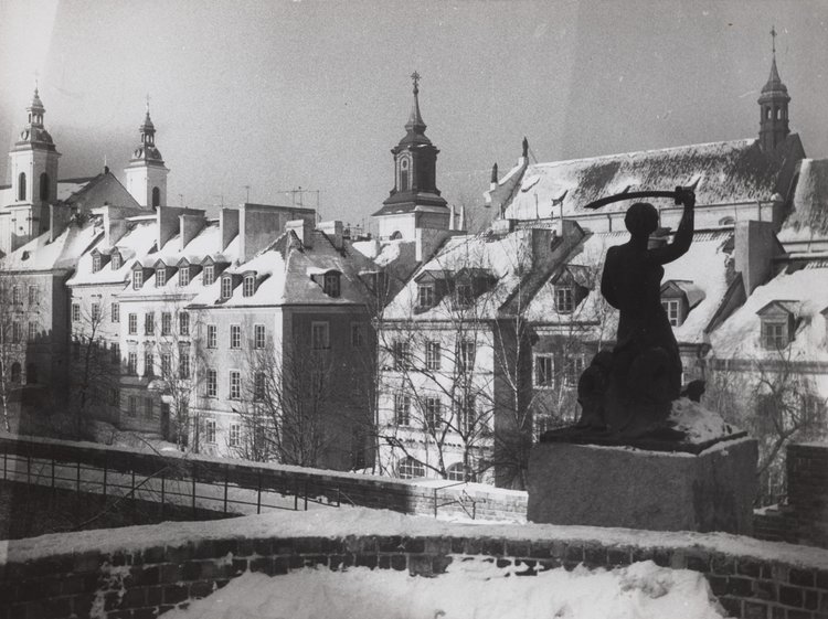 The Mermaid statue on the defensive walls in winter; burgher houses in Mostowa St. in the background