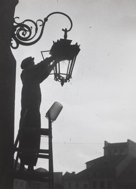 Changing the light bulb of a street lamp in Old Town Market Square
