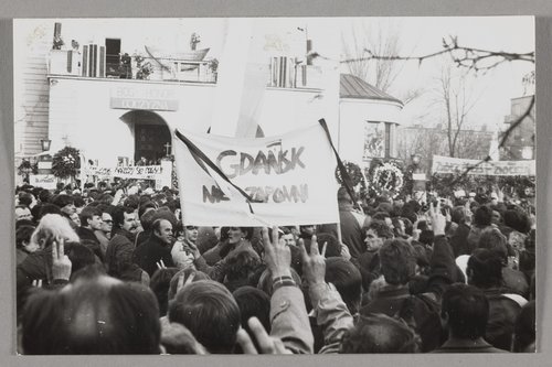 Pogrzeb bł. ks. Jerzego Popiełuszki - ludzie na tle kościoła p.w. św. Stanisława Kostki na warszawskim Żoliborzu trzymający transparenty oraz wyciągnięte w górę prawe ręce