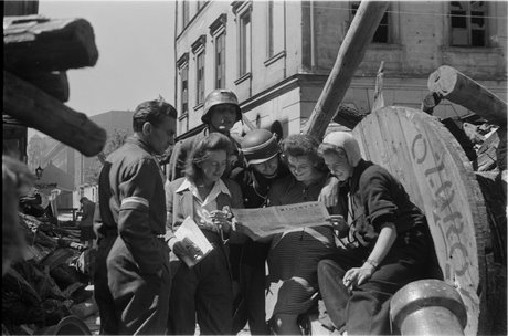 Powstańcy czytający "Biuletyn Informacyjny" na barykadzie