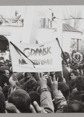 Pogrzeb bł. ks. Jerzego Popiełuszki - ludzie na tle kościoła p.w. św. Stanisława Kostki na warszawskim Żoliborzu trzymający transparenty oraz wyciągnięte w górę prawe ręce