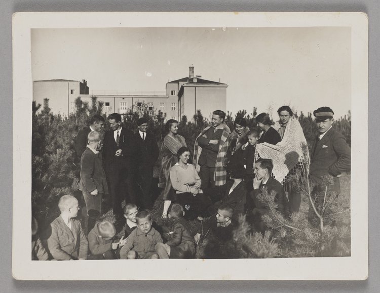 Fotografia przedstawiająca praktykantów i dzieci w ogrodzie Naszego Domu