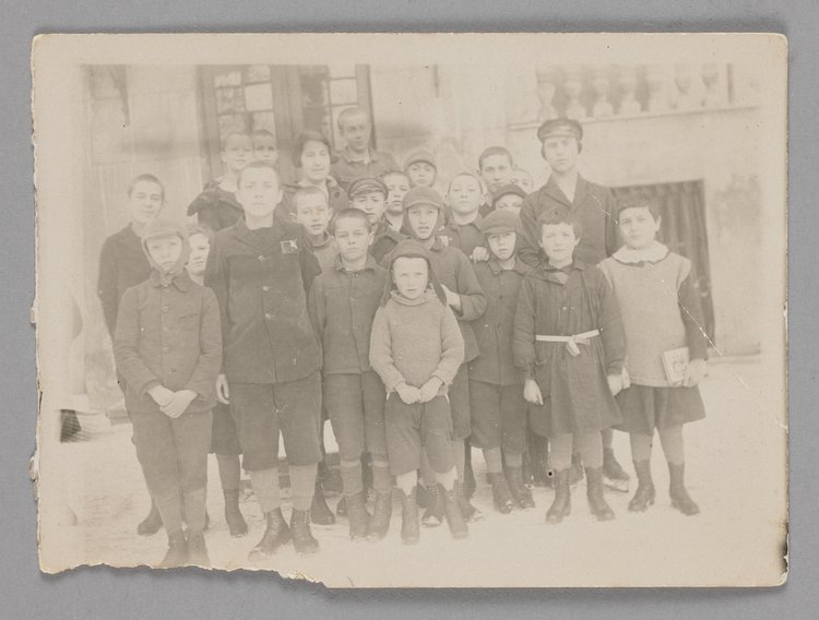 Fotografia przedstawiająca Stefanię Wilczyńską z grupą wychowanków przed Domem Sierot