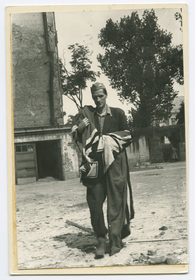 Powstaniec z niemiecka flagą zdobytą w Komendzie Policji