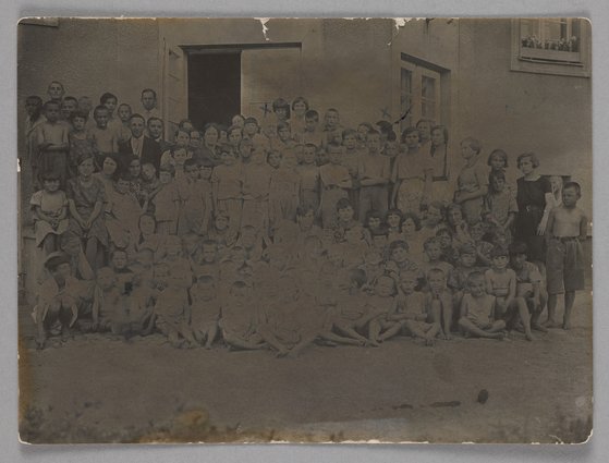 Fotografia przedstawiająca Marię Falską i Janusza Korczaka (Henryka Goldszmita) z wychowankami Naszego Domu