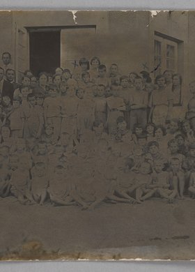 Fotografia przedstawiająca Marię Falską i Janusza Korczaka (Henryka Goldszmita) z wychowankami Naszego Domu