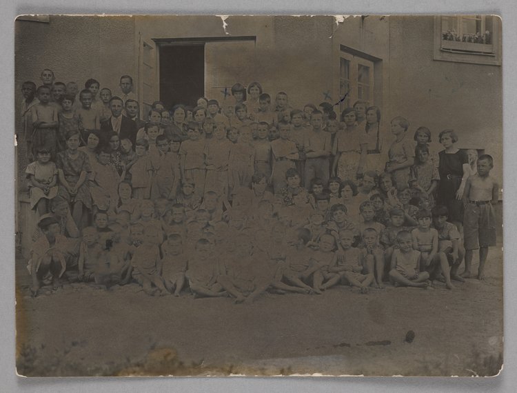 Fotografia przedstawiająca Marię Falską i Janusza Korczaka (Henryka Goldszmita) z wychowankami Naszego Domu