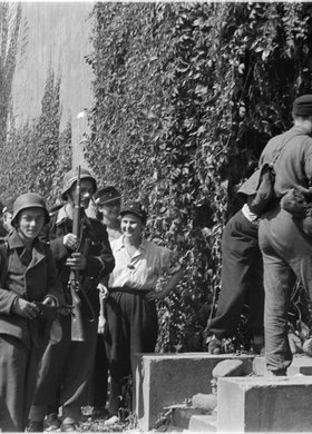 Powstańcy przy ścianie z winem