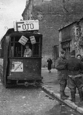 Prowizoryczny punkt usługowy ulicznego fotografa przy zniszczonym wagonie tramwajowym na ulicy Marszałkowskiej
