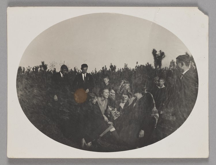 Fotografia przedstawiająca praktykantów i dzieci w ogrodzie Naszego Domu