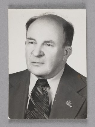 Jerzy Chojnacki w garniturze z przypiętą odznaką