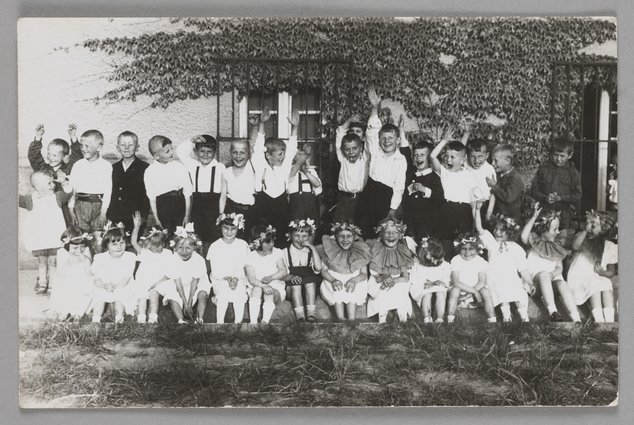 Fotografia przedstawiająca dzieci przed budynkiem Naszego Domu