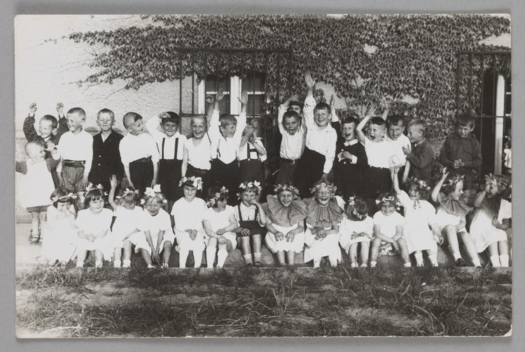 Fotografia przedstawiająca dzieci przed budynkiem Naszego Domu