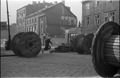 Kobieta przebiegająca ulicą Nowy Świat