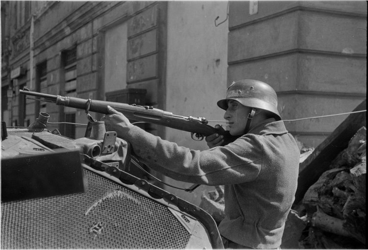 Powstaniec z karabinem na barykadzie